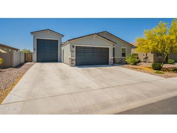 Exterior of house features a spacious driveway with an extra detached garage and gray stone accents at 4215 W Suncup Dr, San Tan Valley, AZ 85144