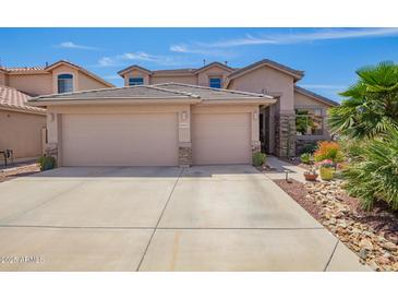 Charming home featuring a three-car garage, desert landscaping, and beautiful stone accents at 44041 W Bailey Dr, Maricopa, AZ 85138