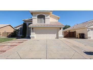 Two-story home featuring a well-manicured lawn and a two-car garage in a sunny neighborhood at 8017 W Eugie Ave, Peoria, AZ 85381