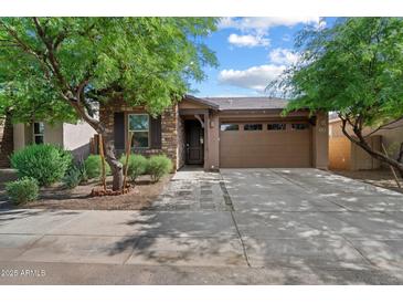 Charming single-story home with a stone facade, well-manicured landscaping, and a two-car garage at 9147 W Minnezona Ave, Phoenix, AZ 85037