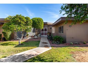 Charming single-story home featuring a well-manicured lawn and desert landscaping, offering a welcoming curb appeal at 10802 W Thunderbird Blvd, Sun City, AZ 85351