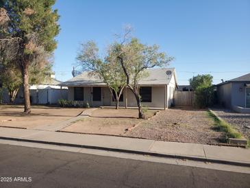 Charming single-story home with mature trees, a walkway to the front door, and desert landscaping at 1363 E Clarendon Ave, Phoenix, AZ 85014
