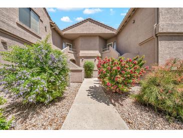 Charming condo exterior featuring colorful landscaping and well-maintained stucco facade at 15151 N Frank Lloyd Wright Blvd # 1088, Scottsdale, AZ 85260