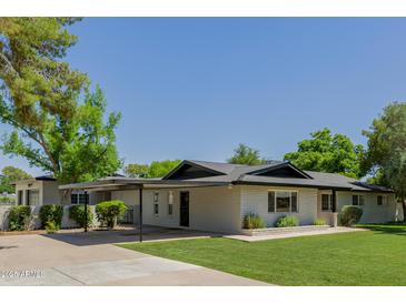 Charming single-story home with a covered parking and a well-manicured lawn at 2350 E Melrose St, Gilbert, AZ 85297