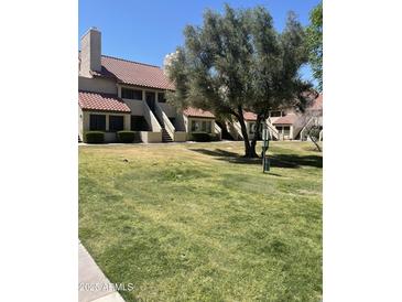 Charming townhouse complex with lush green landscaping and a beautiful red tile roof at 30 E Brown Rd # 2065, Mesa, AZ 85201