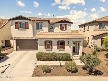 Two-story home featuring brown accents, red shutters, and a two-car garage at 31156 N 137Th Ln, Peoria, AZ 85383