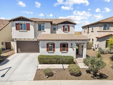 Charming two-story home featuring desert landscaping, a two-car garage, and red window shutters at 31156 N 137Th Ln, Peoria, AZ 85383