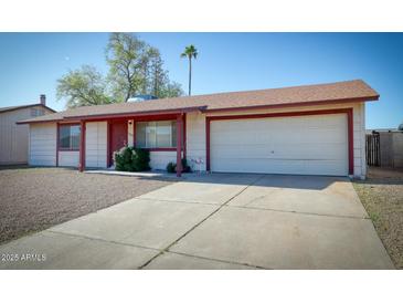 Charming single-level home featuring a two-car garage, low maintenance landscaping, and neutral color scheme at 3209 W Charleston Ave, Phoenix, AZ 85053