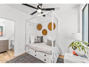 Modern bedroom with a stylish canopy bed, ceiling fan, and minimalist decor at 4220 N 32Nd St # 2, Phoenix, AZ 85018