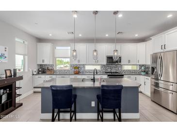 Modern kitchen featuring white cabinets, stainless steel appliances, a gray island, and stylish pendant lighting at 820 N 8Th Ave # 25, Phoenix, AZ 85007
