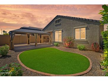 Backyard features a covered patio and lush artificial grass for easy maintenance at 8872 W Hollywood Ave, Peoria, AZ 85345