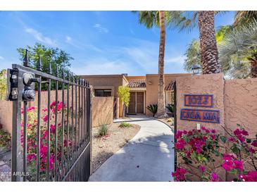 Inviting single-story home entrance with desert landscaping, gated courtyard and a private walkway at 1023 E Sahuaro Dr, Phoenix, AZ 85020