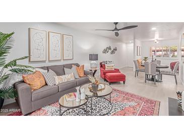 Inviting living room with stylish decor, plush seating, and a modern ceiling fan at 12212 N Paradise Vlg S Pkwy # 113, Phoenix, AZ 85032