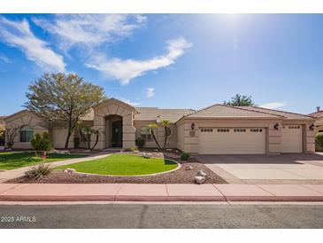 Charming single-story home featuring a desert landscape, mature tree, and a spacious three-car garage at 4055 N Recker Rd # 62, Mesa, AZ 85215