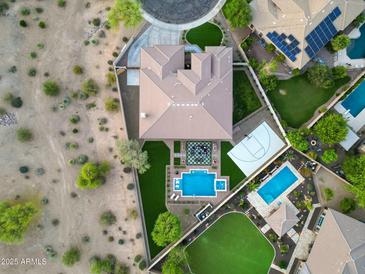 Stunning aerial view of an estate home showcasing a pool, sport court, patio, and lush landscaping at 4417 W El Cortez Trl, Phoenix, AZ 85083