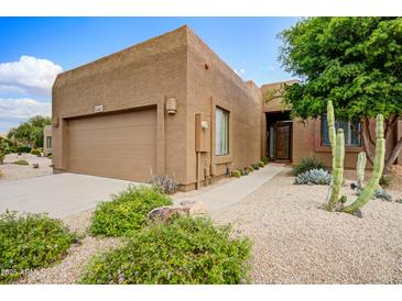 Charming single-story home with desert landscaping, a two-car garage, and inviting entryway at 19115 E Buckskin Ct, Rio Verde, AZ 85263