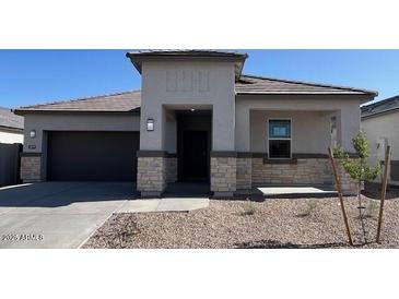 Charming single-story home with a covered porch, neutral palette, and well-manicured front yard at 25473 W Graham Trl, Buckeye, AZ 85326