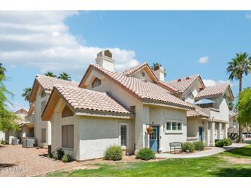 Charming home with a red tile roof, manicured lawn, and inviting blue front door at 2801 N Litchfield Rd # 37, Goodyear, AZ 85395