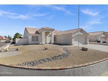 Charming single-story home with a well-maintained yard, decorative rock landscaping and a two car garage at 5046 W Monte Cristo Ave, Glendale, AZ 85306