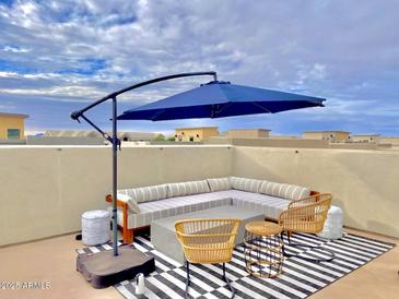 Stylish rooftop patio with modern furniture and an umbrella offering stunning views and relaxation at 7464 E Paraiso Dr, Scottsdale, AZ 85255