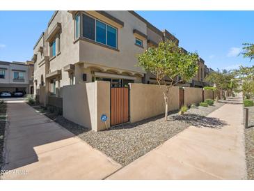 Townhome exterior with private entry and xeriscape landscaping with gated front patio area at 7464 E Paraiso Dr, Scottsdale, AZ 85255