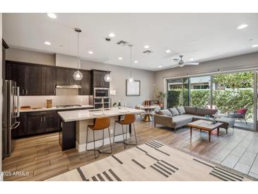 Open-concept kitchen and living room with modern finishes and large windows to outdoor patio at 7464 E Paraiso Dr, Scottsdale, AZ 85255
