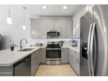 Modern kitchen featuring gray cabinets, stainless steel appliances, a white countertop, and tile flooring at 7531 E Billings St # 116, Mesa, AZ 85207