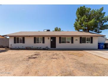 Charming single-story home featuring a well-maintained lawn and inviting entrance at 8111 E Jerome Ave, Mesa, AZ 85209