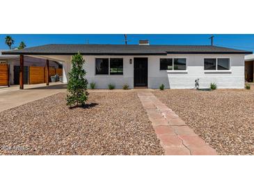 Charming single-story home featuring a landscaped front yard and a welcoming brick pathway at 1308 N 71St St, Scottsdale, AZ 85257