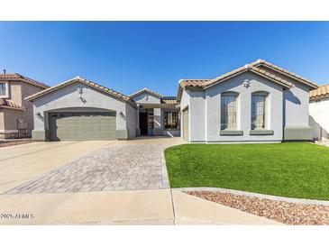 Charming single-story home featuring a well-manicured lawn, wide driveway, and attached two-car garage at 13628 W San Miguel Ave, Litchfield Park, AZ 85340
