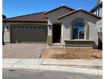 Charming single-story home featuring a tile roof, arched window, and low-maintenance front yard at 15796 W Georgia W Dr, Surprise, AZ 85379