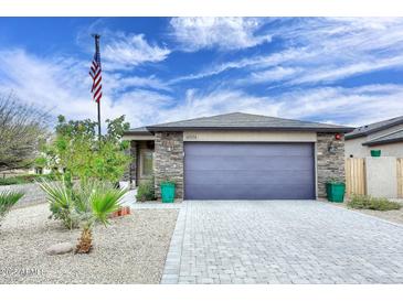Beautiful single-story home with a two-car garage, stone accents, desert landscaping and American flag at 16705 E Almont Dr # A, Fountain Hills, AZ 85268