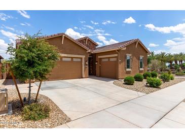 Attractive single-story home featuring a three-car garage, desert landscaping, and a charming stone accent at 24327 N 163Rd Dr, Surprise, AZ 85387