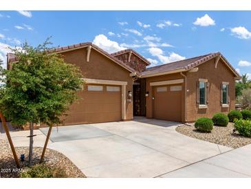 Attractive single-story home featuring a three-car garage, desert landscaping, and a charming stone accent at 24327 N 163Rd Dr, Surprise, AZ 85387