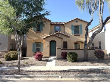 Inviting two-story home featuring colorful flower beds, a charming entryway, and turquoise shutters at 4056 E Devon Dr, Gilbert, AZ 85296