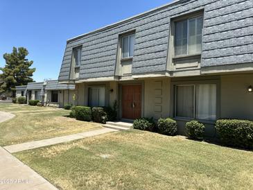 Well-maintained townhome featuring tidy landscaping and a unique roof at 2051 W Elm St, Phoenix, AZ 85015