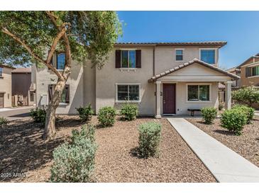 Inviting two-story townhome featuring neutral stucco, dark shutters, and well-maintained front yard landscaping at 2559 N 73Rd Dr, Phoenix, AZ 85035