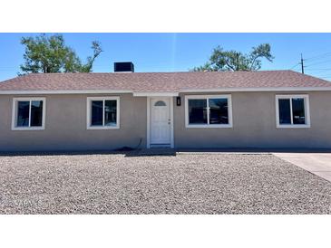 Charming single-story home with freshly painted exterior, updated windows, gravel yard, and manicured landscaping at 3049 W Dahlia Dr, Phoenix, AZ 85029
