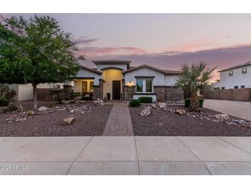 Charming single-story home featuring decorative rock landscaping and a brick walkway leading to the front door at 4282 N 180Th Dr, Goodyear, AZ 85395