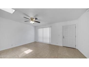 Bright, airy living room with tile floors, ceiling fan, and sliding glass door with vertical blinds at 5229 W Palo Verde Ave, Glendale, AZ 85302