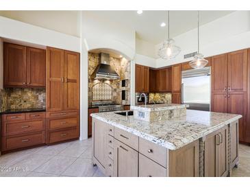 Gourmet kitchen featuring granite countertops, custom cabinets, and top-of-the-line stainless steel appliances at 11856 E Parkview Ln, Scottsdale, AZ 85255