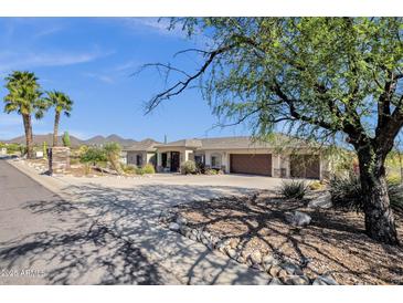 Expansive single-story home with a three-car garage, desert landscaping, and circular driveway at 15620 E Palomino Blvd, Fountain Hills, AZ 85268