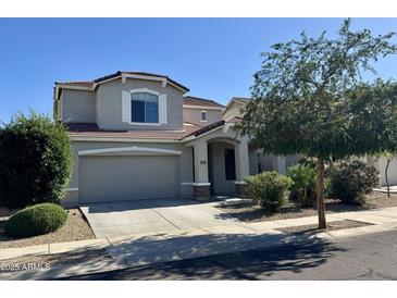 Charming two-story home features a well-maintained front yard and a two car garage at 17477 W Woodrow Ln, Surprise, AZ 85388