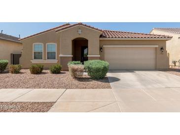 Single-story home with a red tile roof, desert landscaping, and an attached two-car garage at 5612 N 109Th Ave, Phoenix, AZ 85037