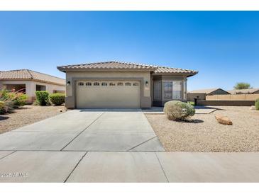 Single-story home with desert landscaping, two-car garage and concrete driveway at 6319 W Hilton Ave, Phoenix, AZ 85043