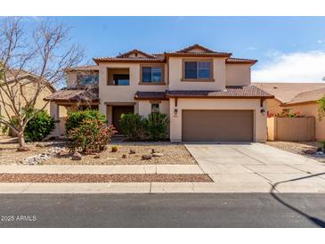 Charming two-story home features a neutral color palette and a well-maintained front yard at 10313 W Windsor Ave, Avondale, AZ 85392