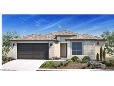 Charming single-story home featuring stone accents, a two-car garage, and desert landscaping at 15695 W Christy Dr, Surprise, AZ 85379