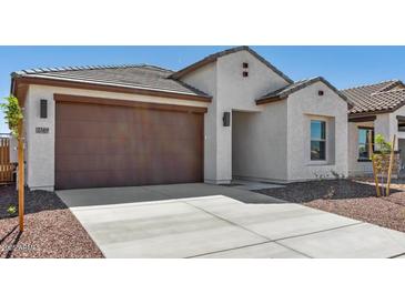 Charming single-story home showcasing a two-car garage and landscaped front yard at 23419 W Albeniz Pl, Buckeye, AZ 85326