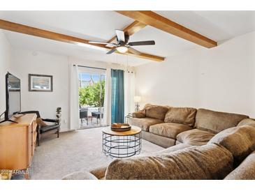 Inviting living room with exposed beam ceiling, ceiling fan and sliding glass doors to the outside at 3314 N 68Th St # 129, Scottsdale, AZ 85251