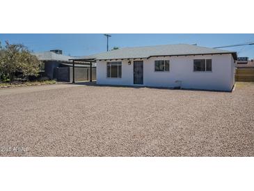 Charming single-story home with rock landscaping, black trim, and shaded carport at 4209 N 48Th Dr, Phoenix, AZ 85031